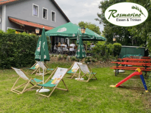 Biergarten mit Liegestühlen, daneben einen kleine Kinderrutsche